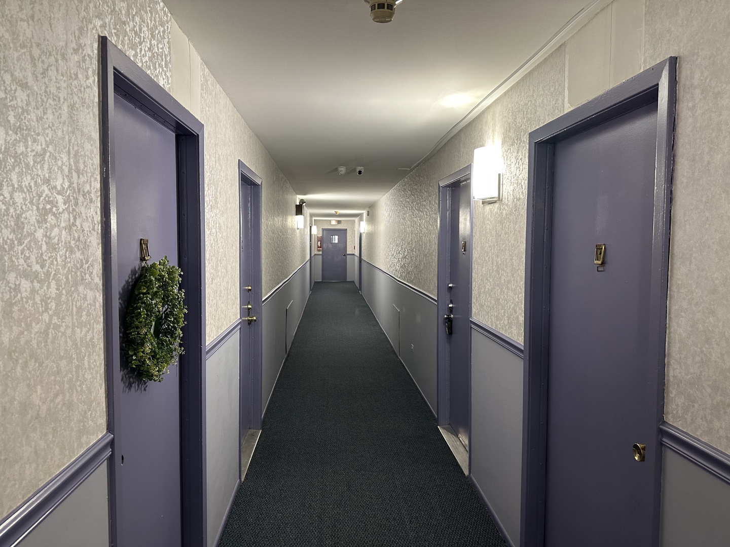 a view of hallway with livingroom and wooden floor