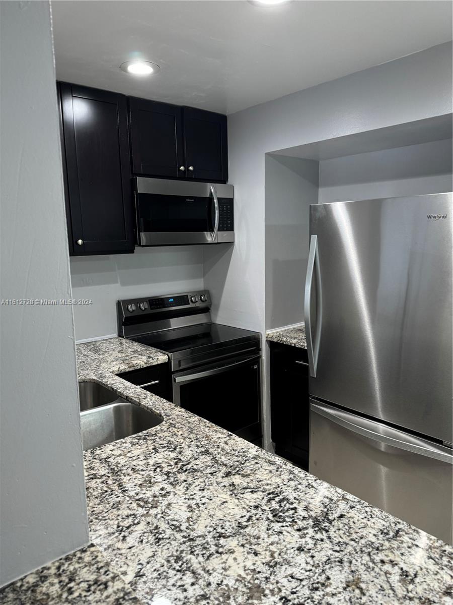 a kitchen with a refrigerator and a stove top oven