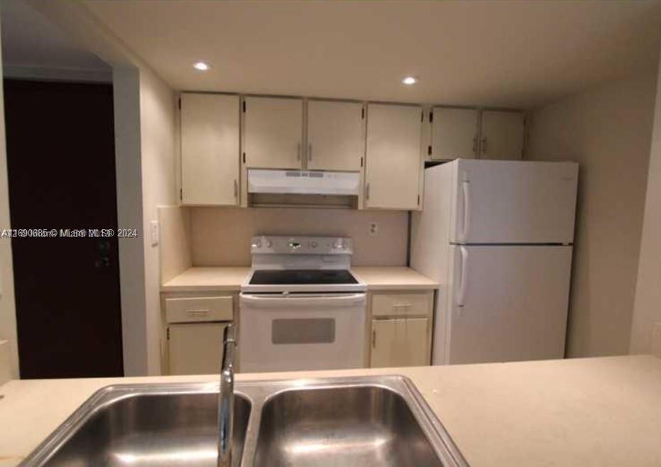 a kitchen with a refrigerator and a sink