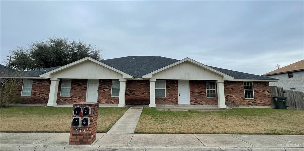 Single story home with a porch and a front yard