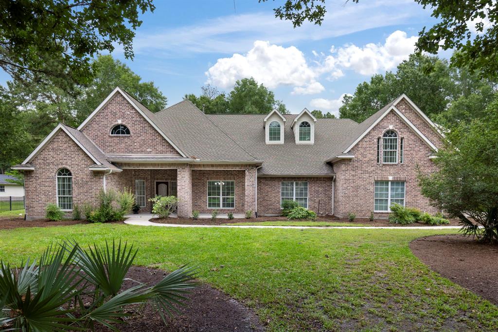 a front view of a house with a yard and potted plants