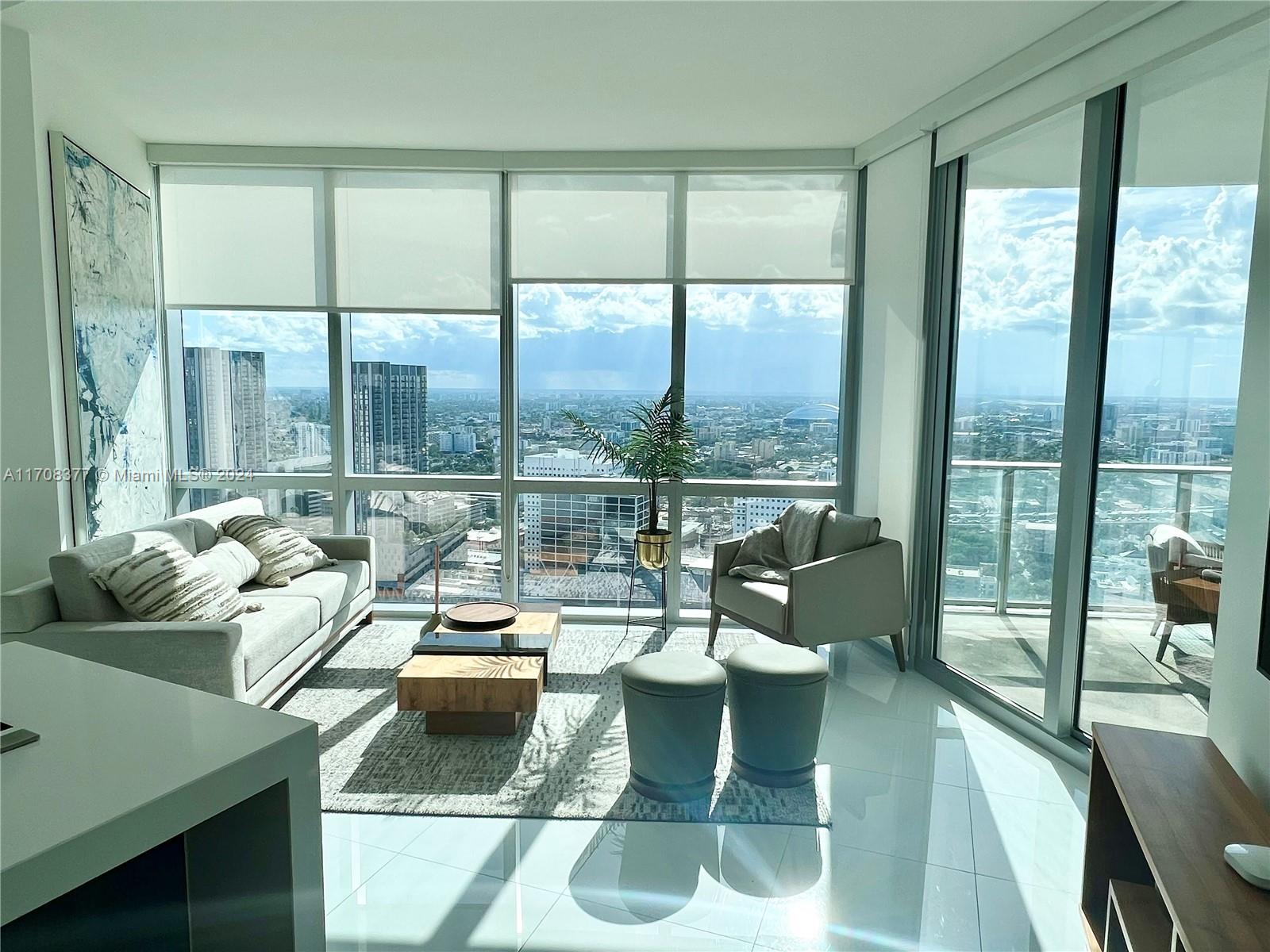 a living room with couches and a floor to ceiling window