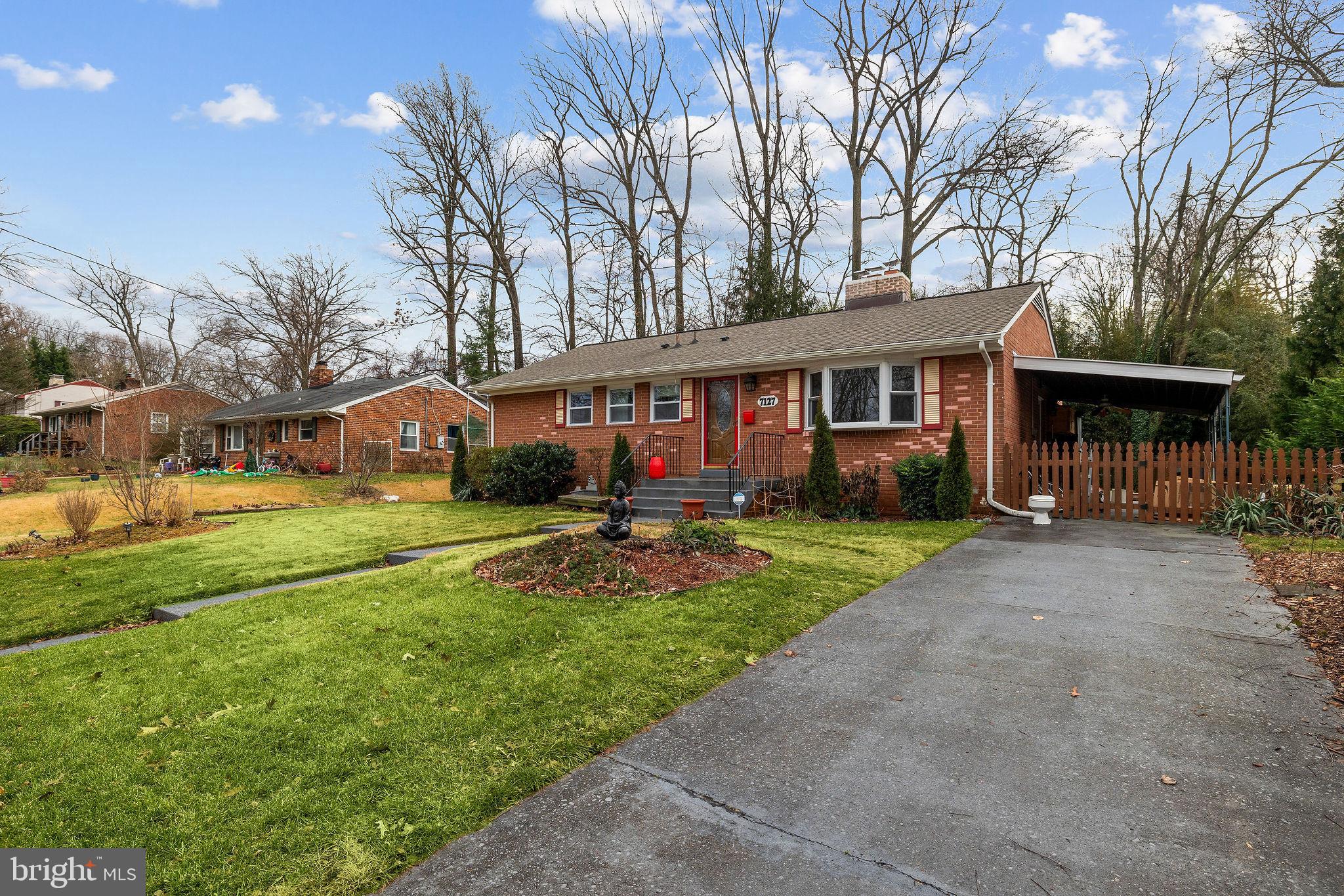 a view of house with a big yard and large trees