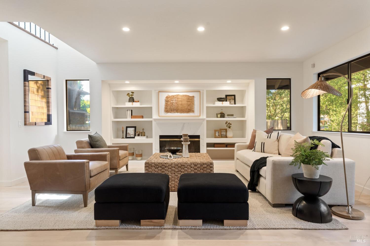 a living room with fireplace furniture and a large window