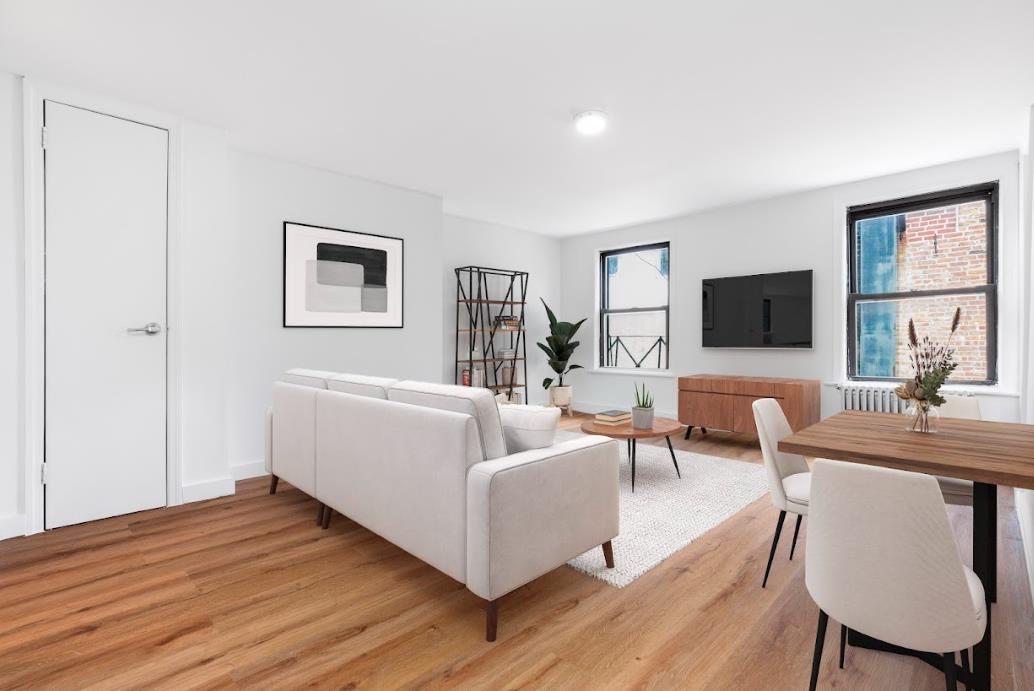 a living room with furniture a flat screen tv and wooden floor