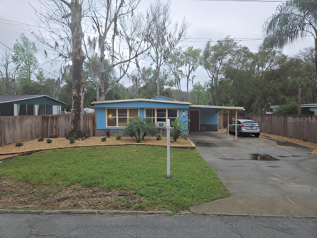 a view of a house with backyard and sitting area