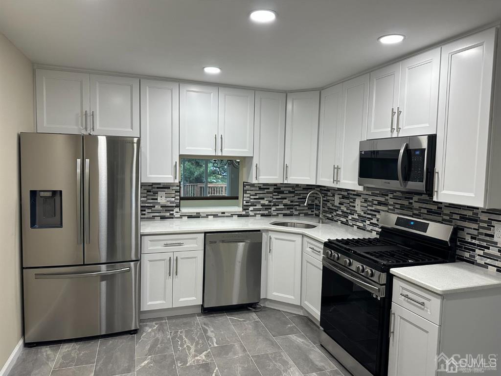 a kitchen with stainless steel appliances granite countertop a refrigerator stove a sink and dishwasher