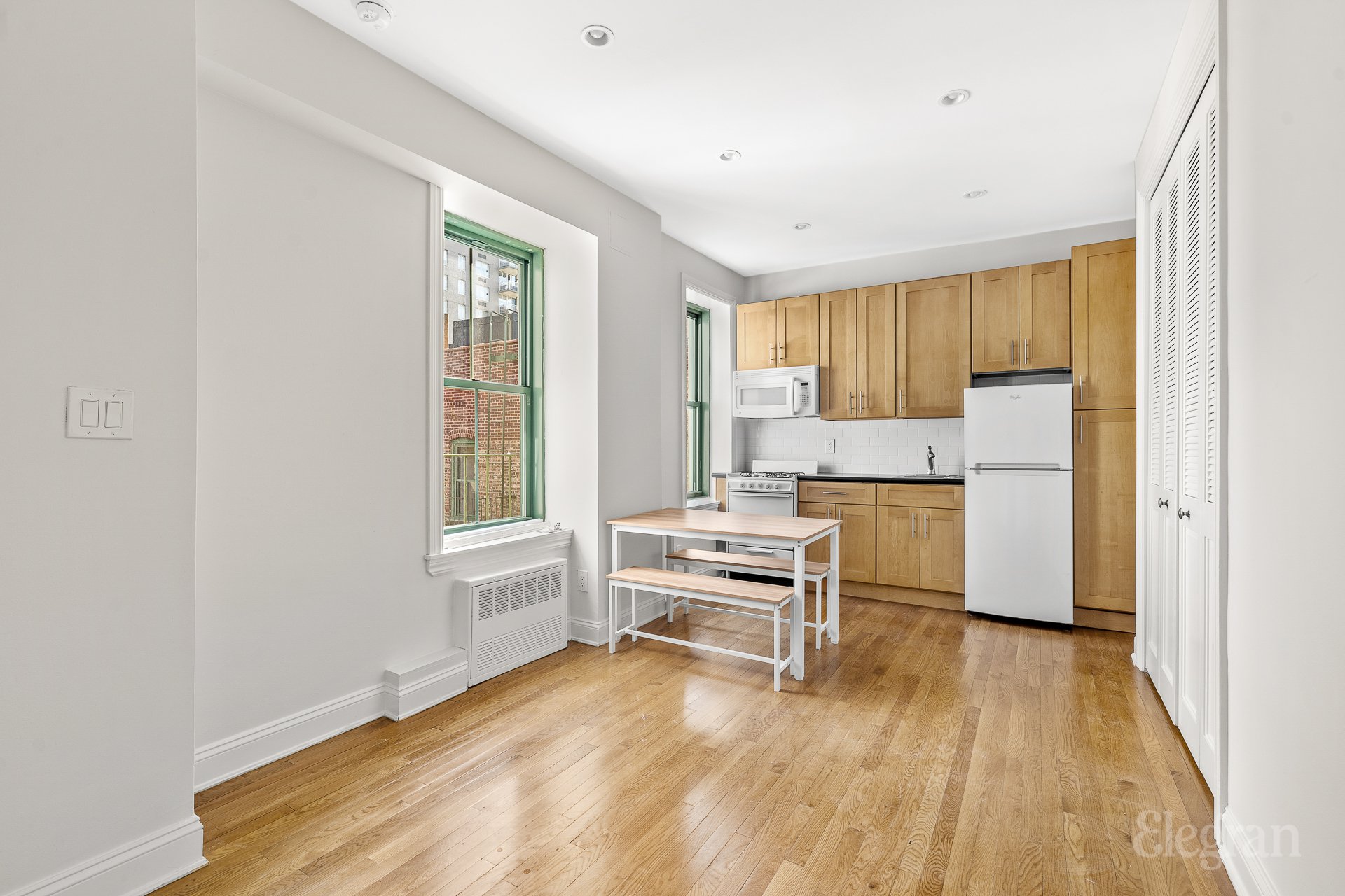 a kitchen with a refrigerator and wooden cabinets