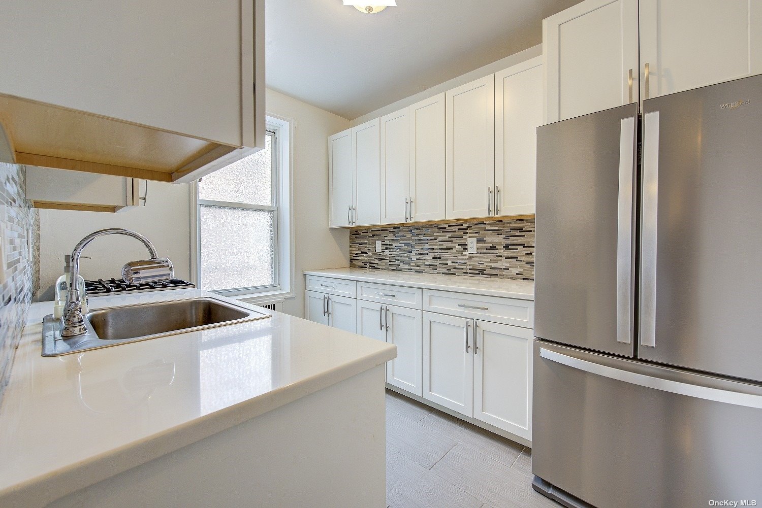 a kitchen with white cabinets and stainless steel appliances