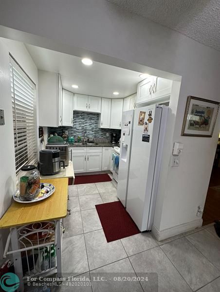 a kitchen with stainless steel appliances granite countertop a refrigerator and a stove