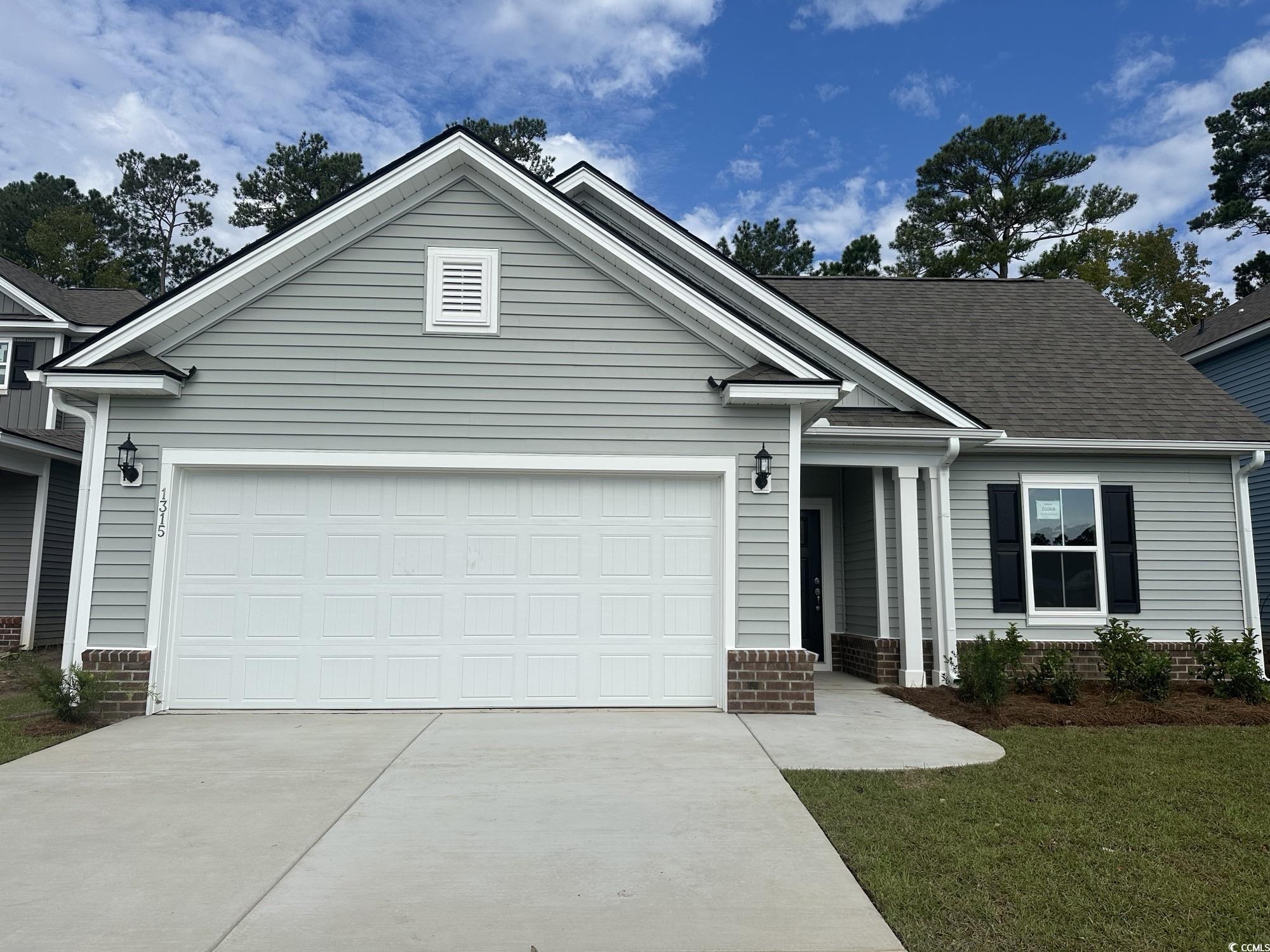 View of front of house with a garage and a front y