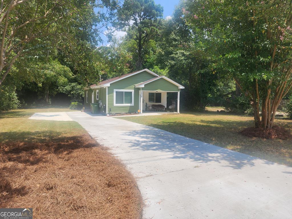 a front view of a house with a yard and trees