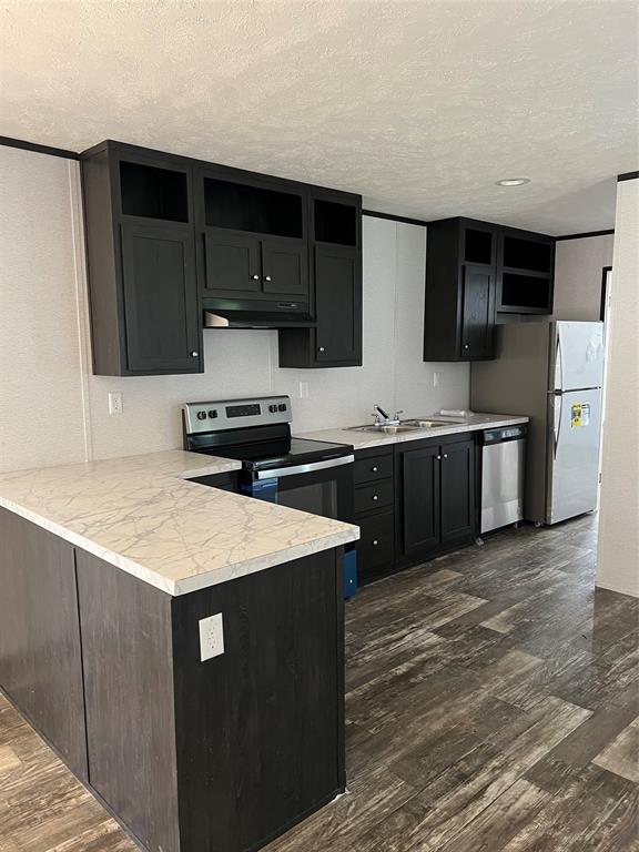 a kitchen with stainless steel appliances a sink dishwasher stove and refrigerator