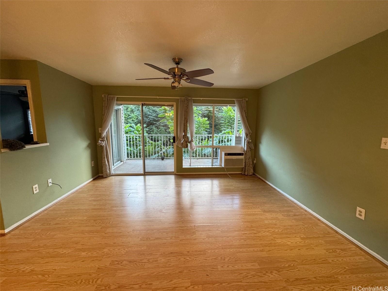 a view of a room with wooden floor and fan