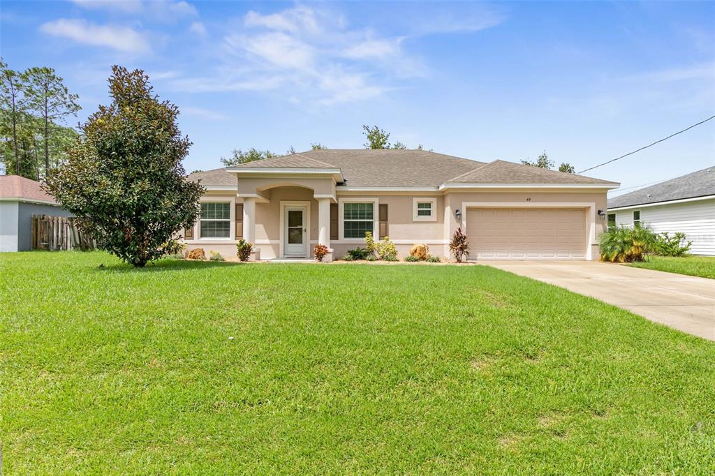 a front view of a house with a yard and trees