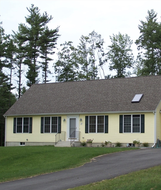 a front view of a house with a garden and yard