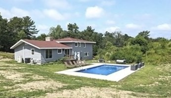 a view of a house with backyard and sitting area