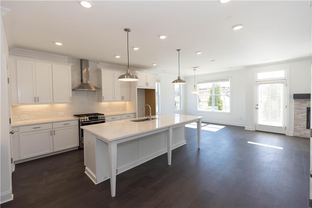 a kitchen with sink stove and wooden floor