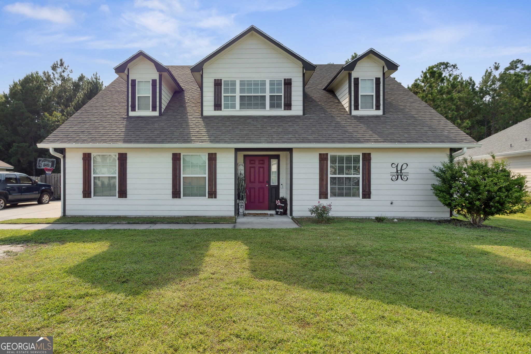 a front view of a house with a garden