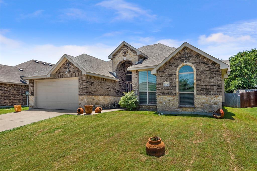 a front view of a house with yard and garage