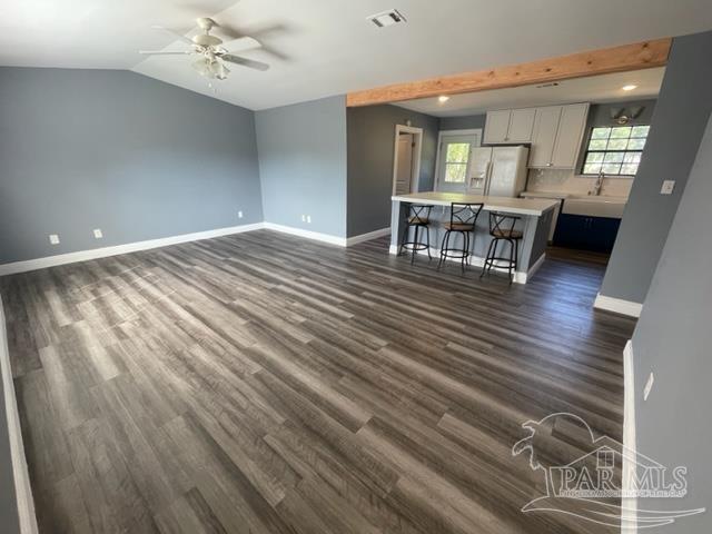 a view of a livingroom with furniture wooden floor and a ceiling fan