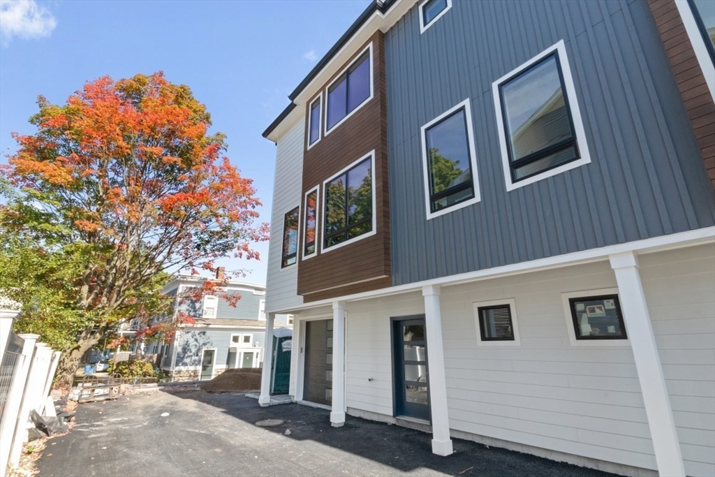 a front view of a building with a tree