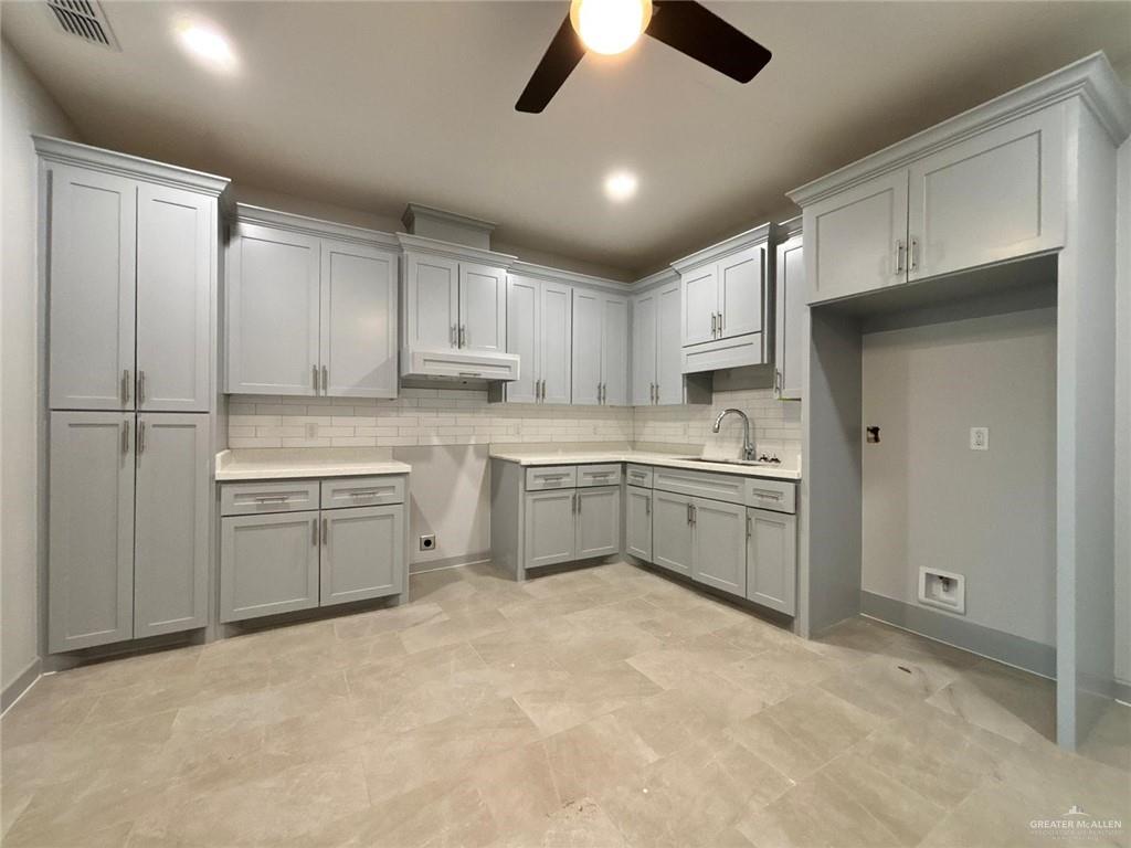 a kitchen with a white stove top oven sink and cabinets