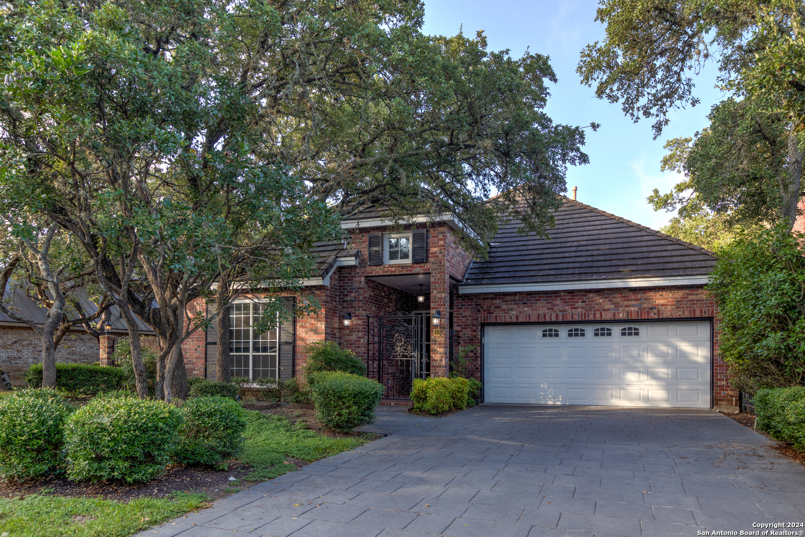 a front view of a house with garage and plants