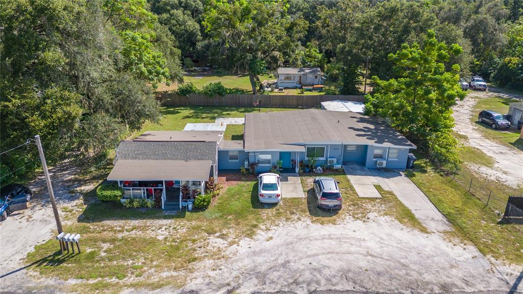 an aerial view of a house with swimming pool and a yard