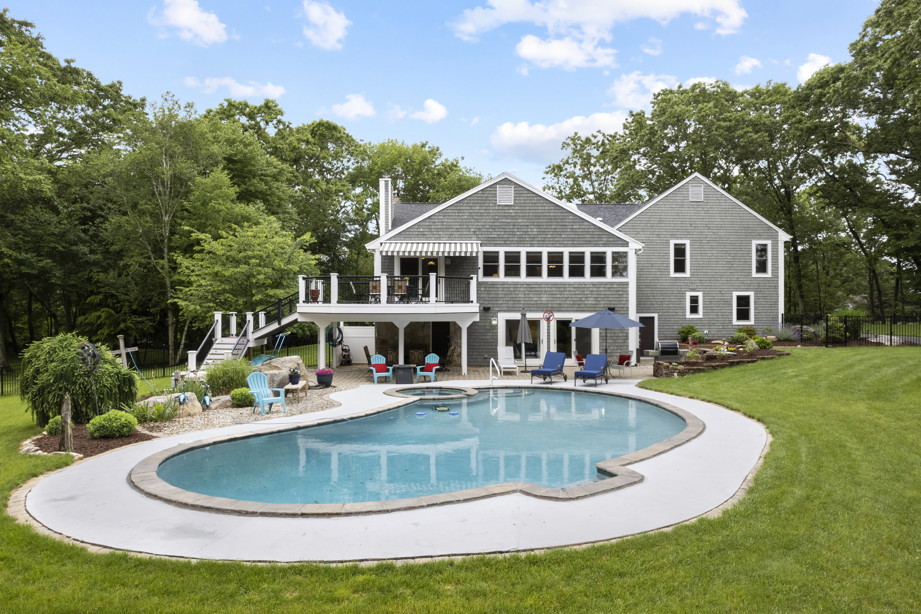 Expansive backyard oasis with a sparkling in-ground pool, cozy lounge area, and lush landscaping - the perfect setting for relaxation and entertainment.