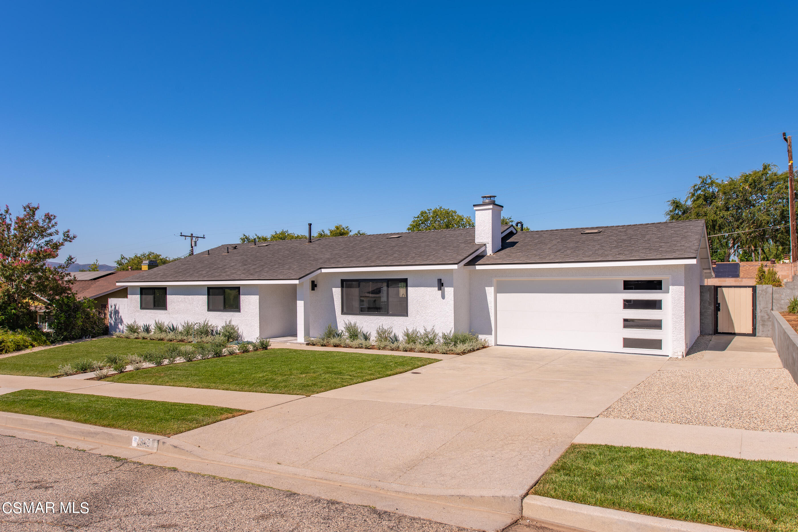 a front view of a house with a garden and yard