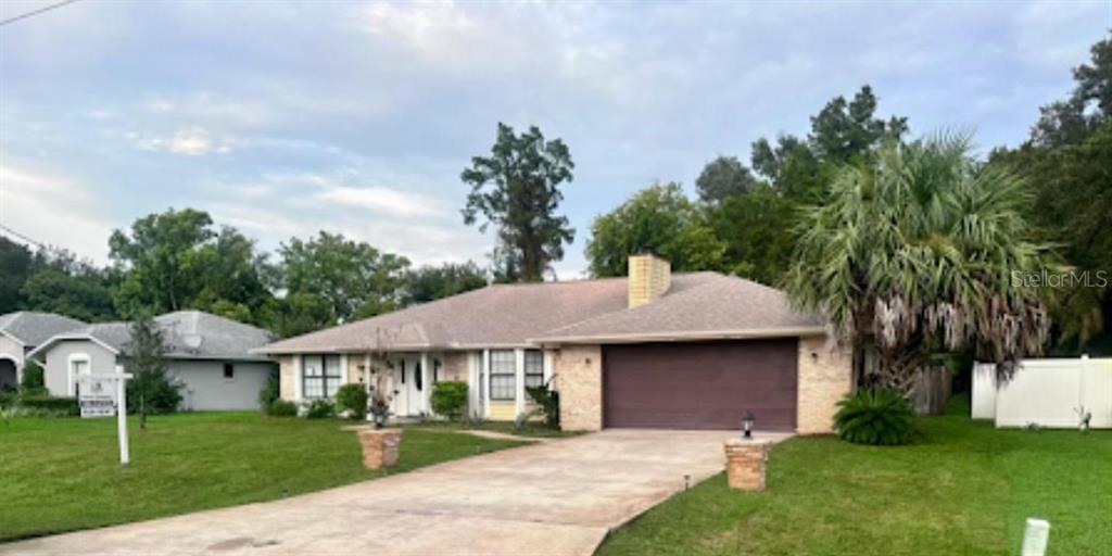 a front view of a house with a garden and trees