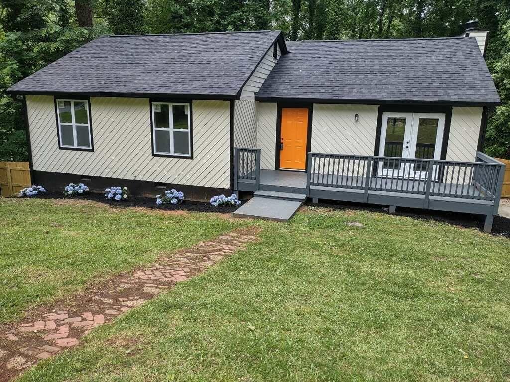 a view of a house with a yard and deck