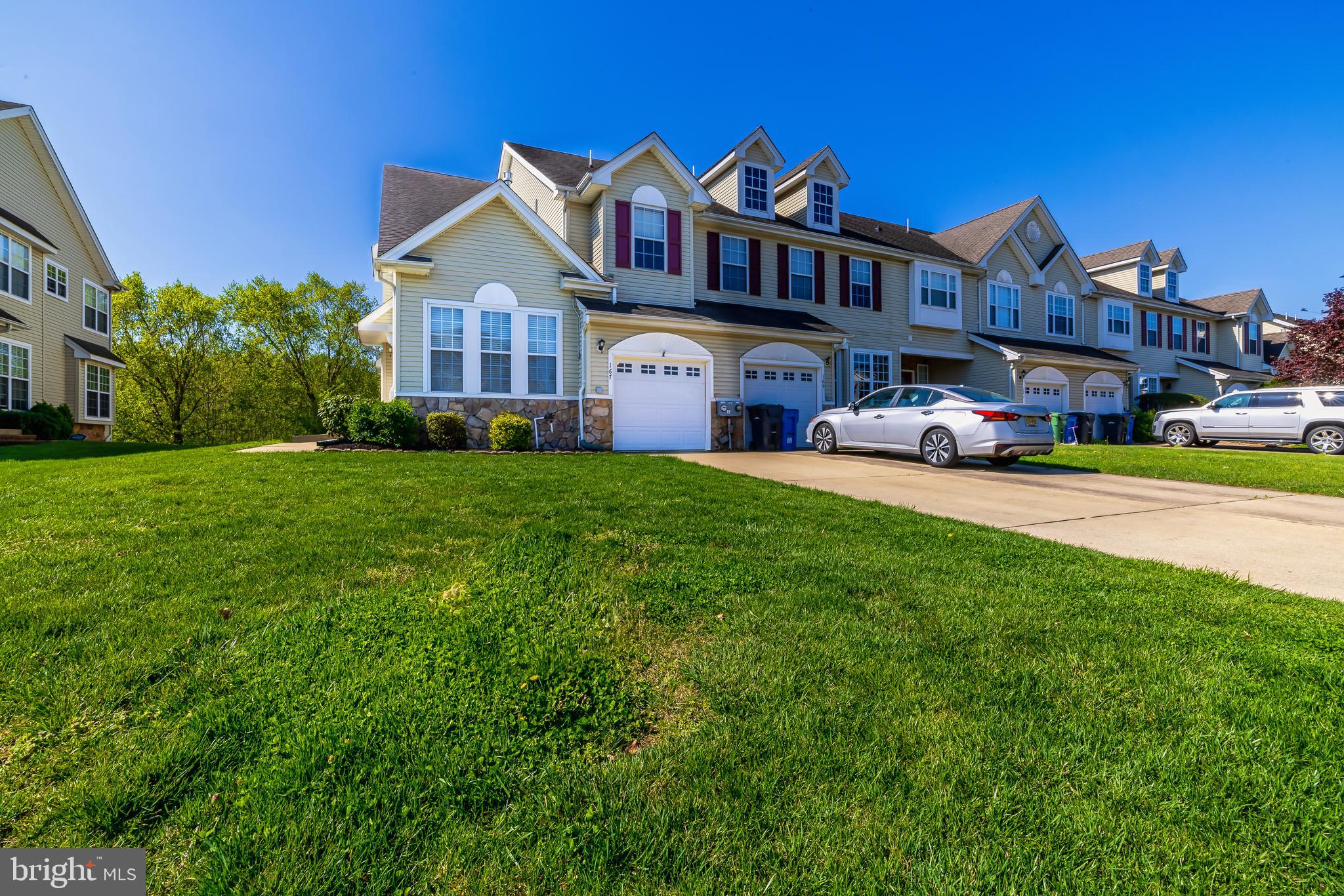 a view of a big house with a big yard and large trees