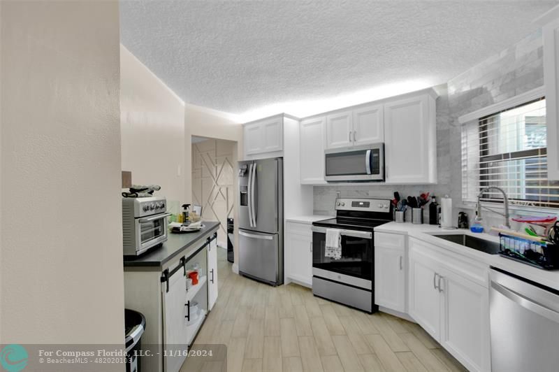 a kitchen with a sink stove and microwave