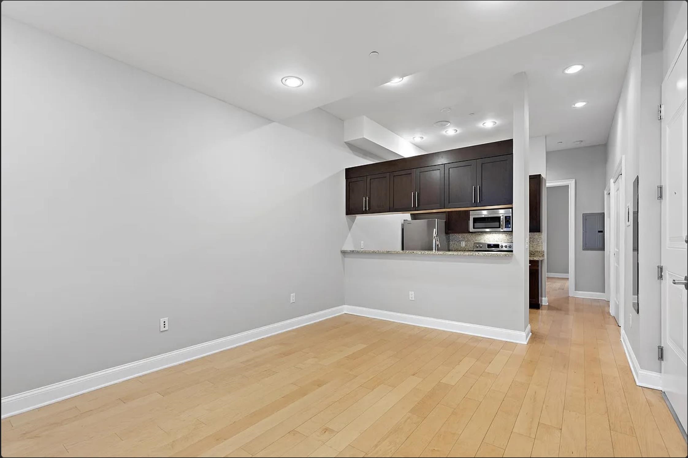 a view of kitchen with stainless steel appliances wooden cabinets and entryway