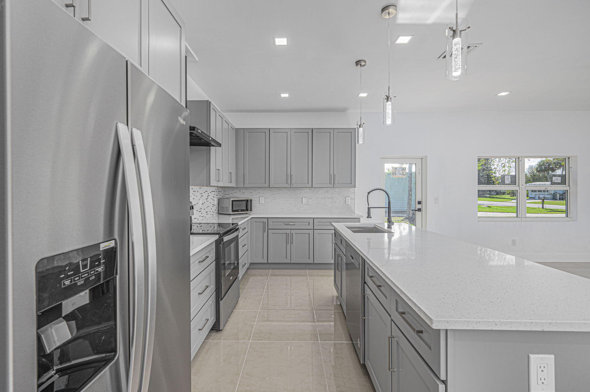 a kitchen with kitchen island white cabinets and stainless steel appliances