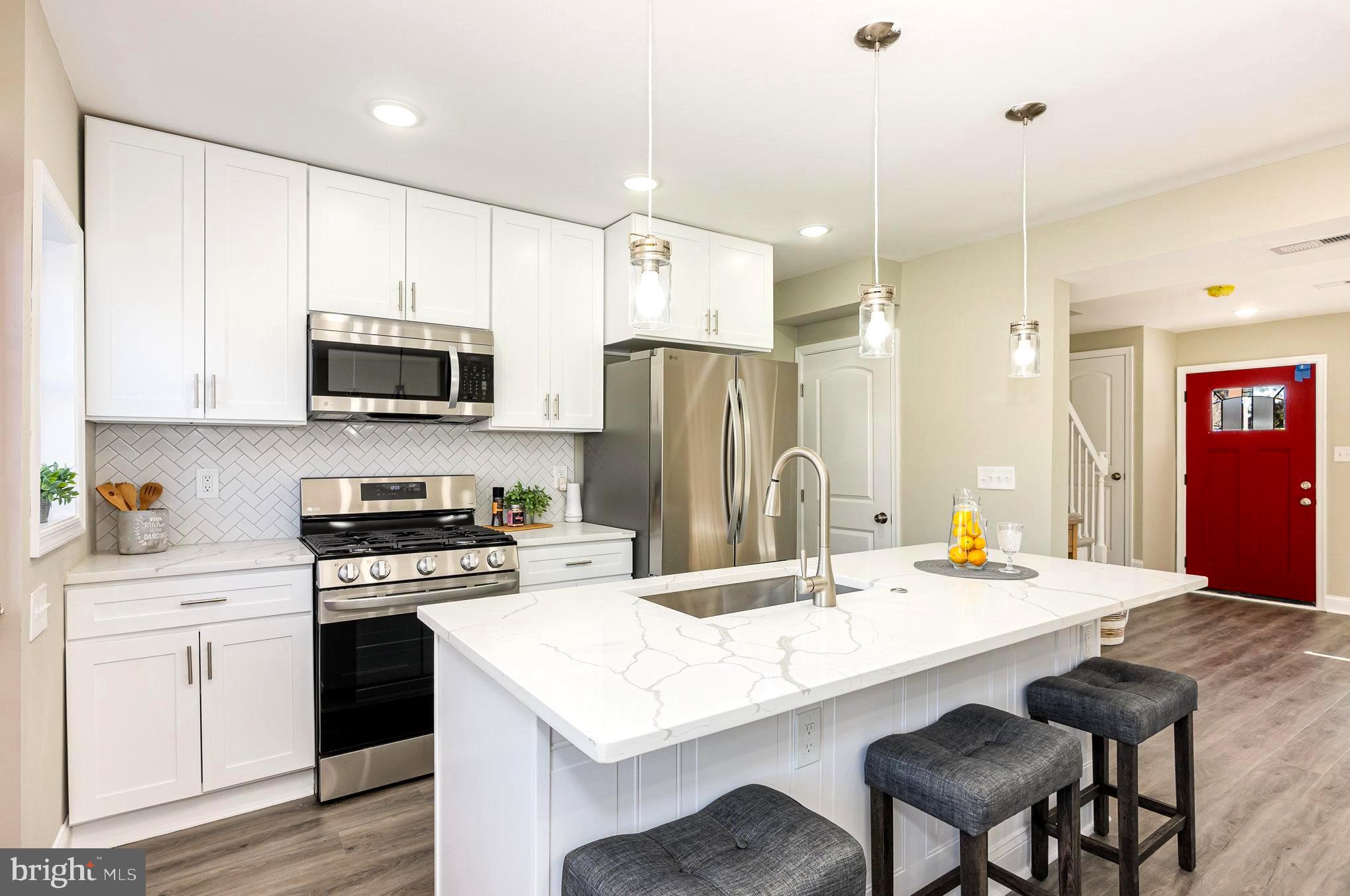 a kitchen with a stove a sink and a refrigerator