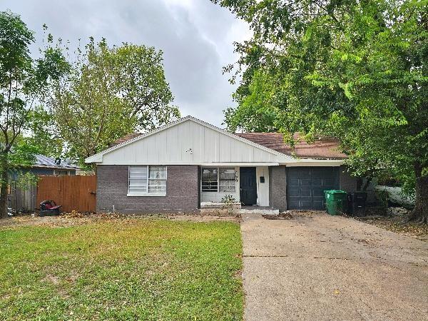 a front view of house with yard and trees around