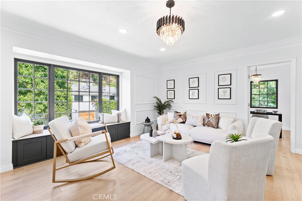 a living room with furniture potted plant and a large window