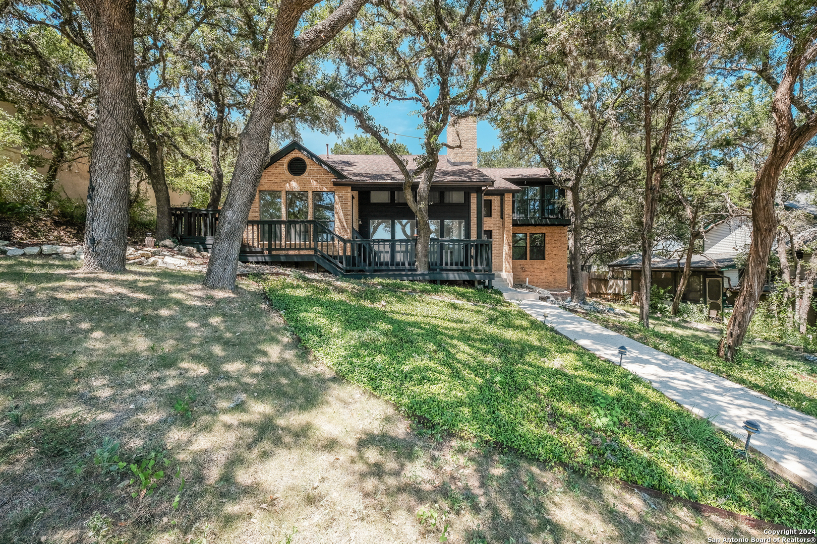 a front view of a house with yard and green space