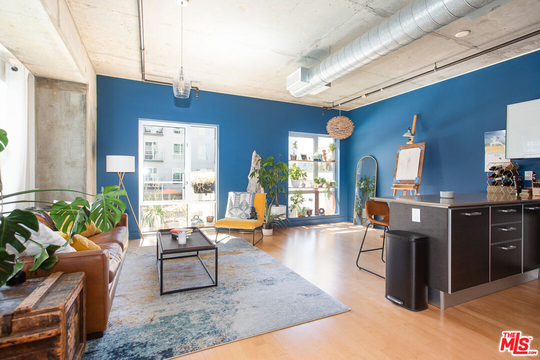 a living room with furniture a wooden floor and a large window