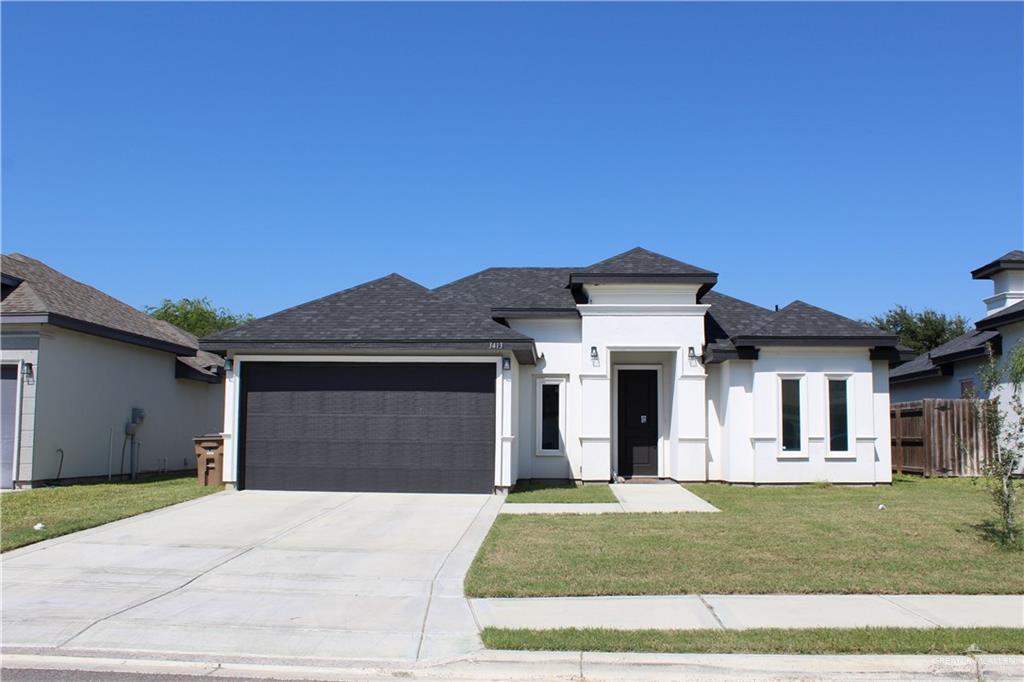 a front view of a house with a yard and garage