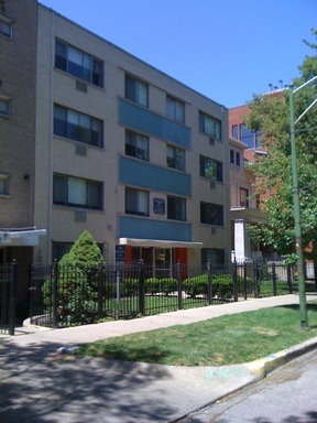 a front view of a building with a garden