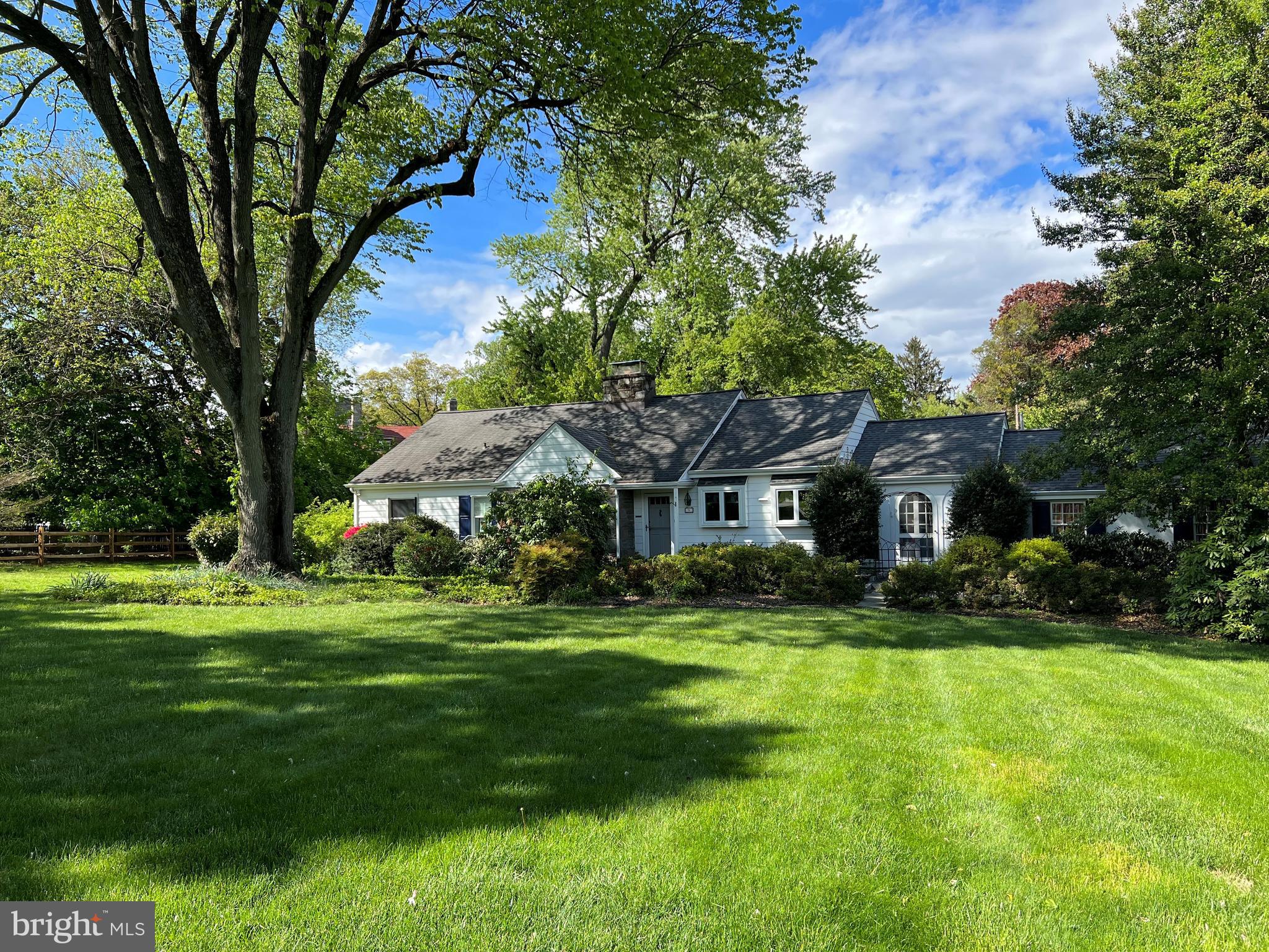 a view of a big house with a big yard and large trees