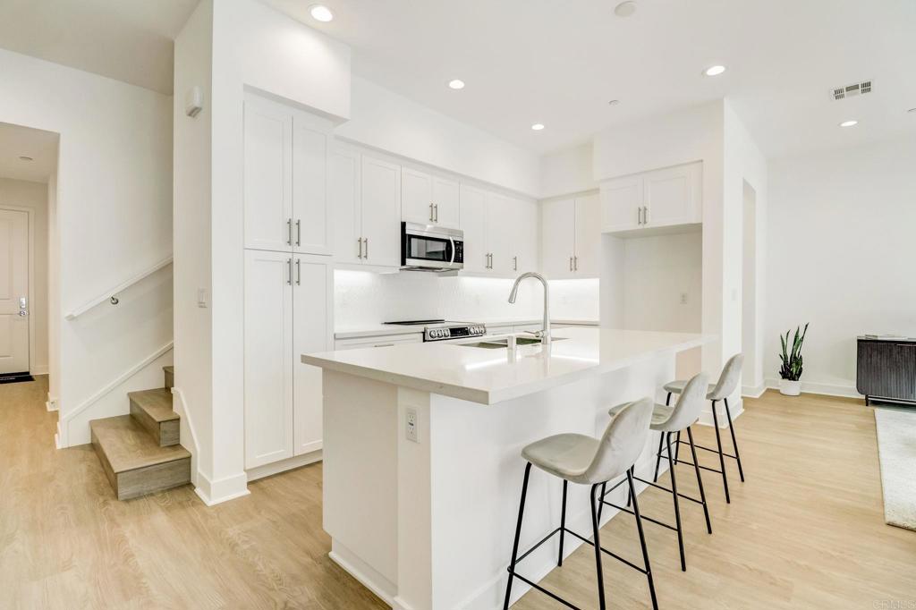 a kitchen with kitchen island white cabinets and stainless steel appliances