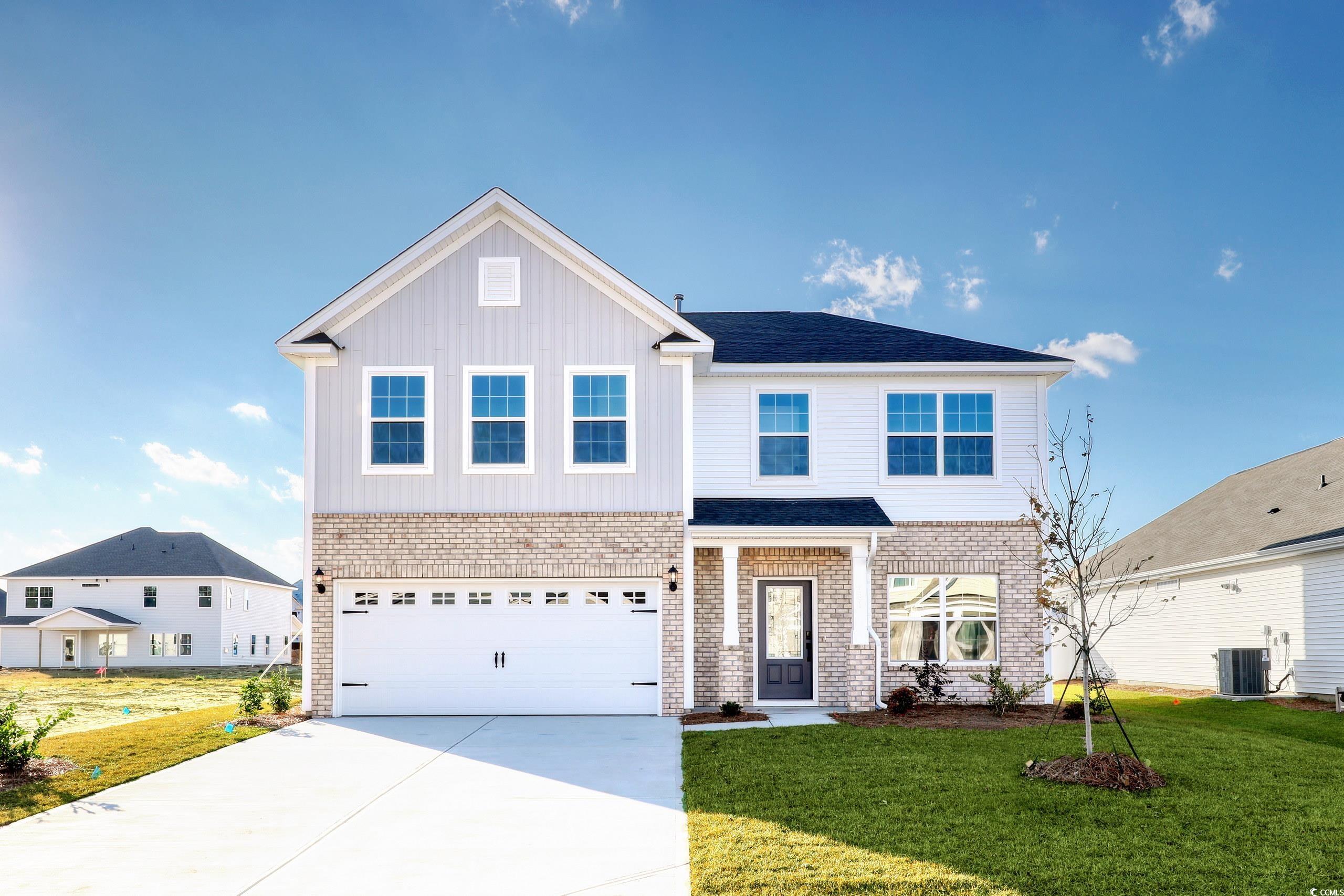 View of front of home featuring central AC, a gara