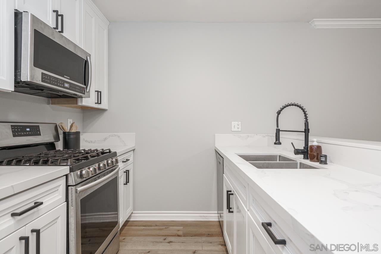 a kitchen with stainless steel appliances granite countertop a sink stove top oven and microwave