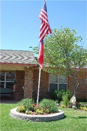 a view of house with a yard and potted plants