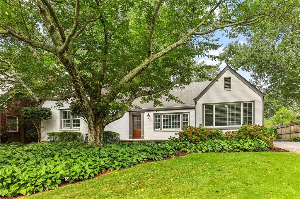 a front view of a house with a yard and trees